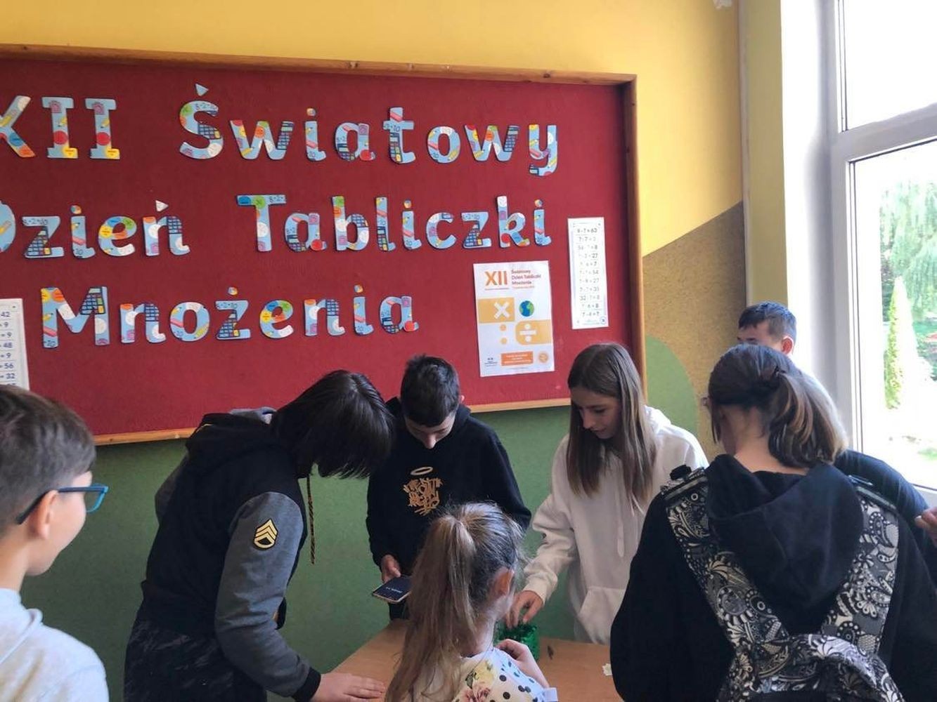 Światowy Dzień Tabliczki Mnożenia to akcja edukacyjna, która odbywa się co roku w pierwszy piątek października. Ma na celu zachęcenie do przypomnienia sobie tabliczki mnożenia w przyjemny i niecodzienny sposób. “Tabliczkowa wiedza” sprawdzana była w naszej szkole podczas krótkiego egzaminu on – line z tabliczki mnożenia. Egzaminatorami na długiej przerwie byli uczniowie klasy VIII c. To oni wyłonili z naszej społeczności “Ekspertów Tabliczki Mnożenia”. Każdy chętny, kto wykonał pozytywnie test otrzymywał odznaczenie eksperta w dziedzinie mnożenia. Do akcji dołączyli nauczyciele i dyrekcja szkoły włączając się do wspólnej zabawy. Koordynatorami akcji były panie Barbara Rokita i  Marzena Szymańska.