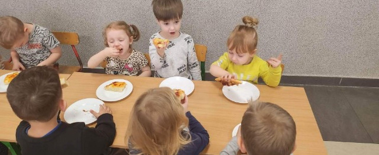 	Dnia 9 lutego we wszystkich grupach przedszkolnych obchodzony był „Międzynarodowy Dzień Pizzy”. Tego dnia sale naszego przedszkola zamieniły się w prawdziwe, włoskie pizzerie. Na zajęciach dzieci miały okazję zobaczyć jak powstaje ten kultowy włoski placek i jakich składników potrzeba, aby go przygotować. Poznały historię jego powstania oraz dowiedziały się, z którego kraju pochodzi. Dzieci w trakcie zabaw świetnie się bawiły, poszukiwały niezbędnych produktów ujętych na liście zakupów i wkładały je do sklepowego koszyka, układały „pizzowe” puzzle oraz tańczyły przy piosence z pizzą w roli głównej. Przedszkolaki miały także możliwość stworzenia w grupach kolorowych, smakowicie wyglądających placków, używając do tego przeróżnych materiałów oraz stosując różne techniki plastyczne. Pomimo, iż pizze te były papierowe, bardzo rozbudzały nasze apetyty. Kulminacyjnym punktem tego wyjątkowego dnia było oczywiście zjedzenie przepysznej, domowej pizzy przygotowanej przez nasze Panie kucharki. To był niezwykle smakowity dzień! Zapraszamy do galerii na fotorelację.