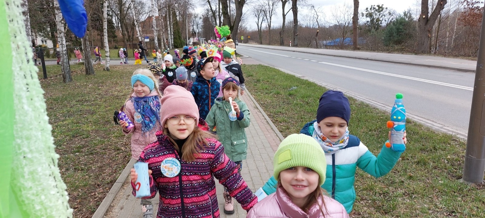 We wtorek 21 marca nasze przedszkole mieniło się kolorami. Wszędzie pojawiły się barwne kwiaty i motyle, a wszystko to za sprawą długo oczekiwanego gościa: Pani Wiosny. Zaraz po drugim śniadaniu ruszyliśmy kolorowym korowodem pobliskimi ulicami. Oczywiście zgodnie z tradycją z marzanną na czele. Wyposażeni w domowej roboty grzechotki, różnego rodzaju instrumenty oraz tęczowe gaiki skandowaliśmy głośno i śpiewaliśmy wiosenne piosenki. Nasze małe czary chyba zadziałały, ponieważ po południu zima zdecydowanie ustąpiła wiośnie, która powitała nas piękną pogodą i łaskoczącymi promieniami słońca. 