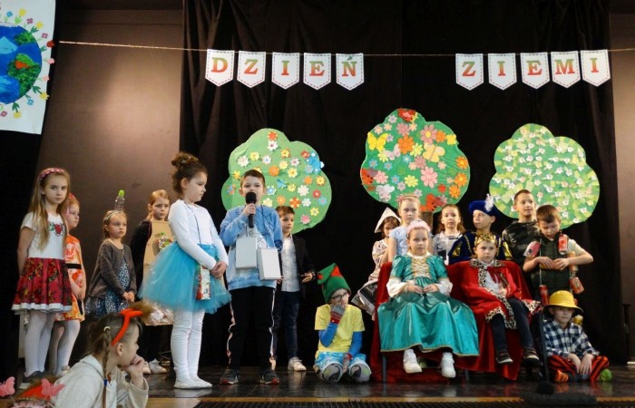 21 kwietnia 2023 roku w naszej szkole odbył się apel poświęcony problematyce segregacji odpadów. Uczniowie z klas drugich i trzecich, a następnie dzieci z grup przedszkolnych, z wielkim zainteresowaniem obejrzeli sztukę o tarapatach w Królestwie Jego  Królewskiej  Mości, Króla Surowca Wtórnego. Niedobrze żyło się poddanym w tym zaśmieconym Królestwie. Ludzie nie dbali o porządek, rzucali zbędne opakowania byle gdzie, szklane butelki zostawiali w lesie, a metalowe puszki w parku pod ławką. Poddani zwrócili się do Króla Surowca Wtórnego o pomoc w rozwiązaniu tego problemu. Rozwiązanie znaleźli  najmłodsi członkowie rodziny królewskiej: Królewicz Surowczyk i Królewna Surówka. Zaproponowali segregację odpadów w królestwie, poprzez ustawienie koszy na ulicach z napisami, co wrzucać do którego kosza. Wszystkim zebranym pomysł się bardzo spodobał .Humorystyczna tematyka apelu uwrażliwiła naszych uczniów na problem segregacji odpadów we własnych rodzinach, możliwości ograniczenia ilości wytwarzanych śmieci oraz dbałości o najbliższe otoczenie.   Aktorami przedstawienia byli uczniowie klas: IA i IB pod kierunkiem wychowawczyń: Danuty Prokop i Ewy Kilian.