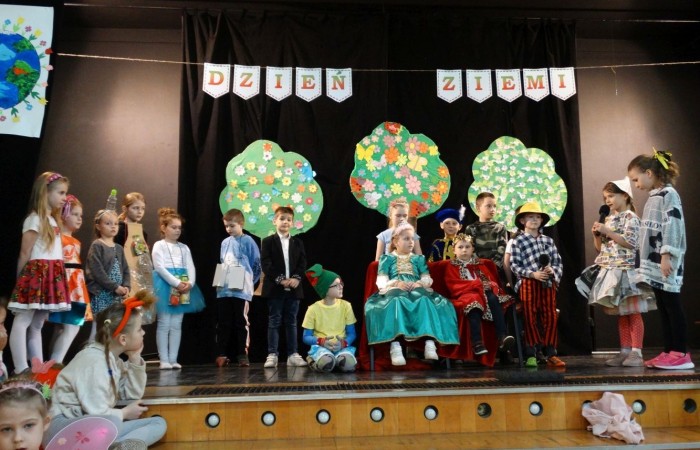 21 kwietnia 2023 roku w naszej szkole odbył się apel poświęcony problematyce segregacji odpadów. Uczniowie z klas drugich i trzecich, a następnie dzieci z grup przedszkolnych, z wielkim zainteresowaniem obejrzeli sztukę o tarapatach w Królestwie Jego  Królewskiej  Mości, Króla Surowca Wtórnego. Niedobrze żyło się poddanym w tym zaśmieconym Królestwie. Ludzie nie dbali o porządek, rzucali zbędne opakowania byle gdzie, szklane butelki zostawiali w lesie, a metalowe puszki w parku pod ławką. Poddani zwrócili się do Króla Surowca Wtórnego o pomoc w rozwiązaniu tego problemu. Rozwiązanie znaleźli  najmłodsi członkowie rodziny królewskiej: Królewicz Surowczyk i Królewna Surówka. Zaproponowali segregację odpadów w królestwie, poprzez ustawienie koszy na ulicach z napisami, co wrzucać do którego kosza. Wszystkim zebranym pomysł się bardzo spodobał .Humorystyczna tematyka apelu uwrażliwiła naszych uczniów na problem segregacji odpadów we własnych rodzinach, możliwości ograniczenia ilości wytwarzanych śmieci oraz dbałości o najbliższe otoczenie.   Aktorami przedstawienia byli uczniowie klas: IA i IB pod kierunkiem wychowawczyń: Danuty Prokop i Ewy Kilian.