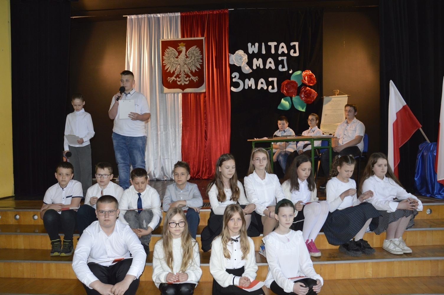 28 kwietnia odbyła się uroczysta akademia z okazji 232 rocznicy uchwalenia Konstytucji 3 Maja, pierwszej w Europie i drugiej na świecie ustawy, która regulowała system prawny naszego państwa, wprowadzając ustrój monarchii konstytucyjnej. Choć obowiązywała zaledwie przez 14 miesięcy, była próbą ratowania suwerenności, zagrożonej wówczas agresją sąsiadów, Polski.
   W apelu wzięli udział uczniowie z klas IV-VIII , którzy tego dnia przyszli do szkoły w galowym stroju. Uroczystość rozpoczęto odśpiewaniem hymnu narodowego. Następnie młodzi aktorzy z klas Va i Vb wcielili się w role, by przybliżyć nam to, co stanowi nieodłączny element naszej tożsamości narodowej - czyny Wielkich Polaków i ich znaczenie dla przyszłości kraju. Mimo podniosłego nastroju, znalazło się także miejsce na odrobinę humoru.
   Spotkanie to było doskonałą lekcją historii, dla starszych uczniów powtórką najważniejszych wydarzeń z  przeszłości naszej Ojczyzny, dla młodszych wprowadzeniem w świat zawiłych losów minionych pokoleń Polaków. Całość przedstawienia uświetniły pieśni patriotyczne przygotowane przez p. I. Matukiewicz.