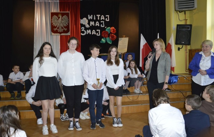 28 kwietnia odbyła się uroczysta akademia z okazji 232 rocznicy uchwalenia Konstytucji 3 Maja, pierwszej w Europie i drugiej na świecie ustawy, która regulowała system prawny naszego państwa, wprowadzając ustrój monarchii konstytucyjnej. Choć obowiązywała zaledwie przez 14 miesięcy, była próbą ratowania suwerenności, zagrożonej wówczas agresją sąsiadów, Polski.
   W apelu wzięli udział uczniowie z klas IV-VIII , którzy tego dnia przyszli do szkoły w galowym stroju. Uroczystość rozpoczęto odśpiewaniem hymnu narodowego. Następnie młodzi aktorzy z klas Va i Vb wcielili się w role, by przybliżyć nam to, co stanowi nieodłączny element naszej tożsamości narodowej - czyny Wielkich Polaków i ich znaczenie dla przyszłości kraju. Mimo podniosłego nastroju, znalazło się także miejsce na odrobinę humoru.
   Spotkanie to było doskonałą lekcją historii, dla starszych uczniów powtórką najważniejszych wydarzeń z  przeszłości naszej Ojczyzny, dla młodszych wprowadzeniem w świat zawiłych losów minionych pokoleń Polaków. Całość przedstawienia uświetniły pieśni patriotyczne przygotowane przez p. I. Matukiewicz.