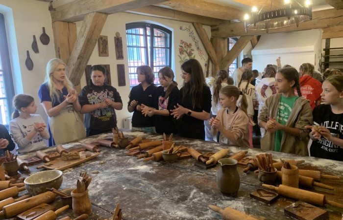 19 maja uczniowie klas 5a i 5b odwiedzili rodzinne miasto Mikołaja Kopernika. Zwiedzanie Torunia rozpoczęliśmy od Krzywej Wieży. Tutaj mogliśmy sprawdzić naszą prawość i uczciwość, gdyż według legendy tylko człowiek bez grzechu może utrzymać równowagę opierając się o jej ścianę. Następnie pan przewodnik oprowadził nas po Starym Mieście. Zobaczyliśmy dom i pomnik Mikołaja Kopernika, podziwialiśmy gotyckie kamienice, Bramę Klasztorną, Ratusz Staromiejski, Katedrę św. Jana Chrzciciela i św. Jana Ewangelisty. Poznaliśmy historię miasta i losy Mikołaja Kopernika. 
Kolejnym punktem programu było Żywe Muzeum Piernika. Pod okiem mistrza Dawida poznaliśmy rytuały związane z wypiekiem piernika. Własnoręcznie przygotowaliśmy ciasto i przy użyciu drewnianych form upiekliśmy pierniczki. Po warsztatach mieliśmy okazję zobaczyć manufakturę z początku XX wieku, maszyny służące do wypieku piernika, zabytkowy piec oraz kolekcję form woskowych.
Ostatnią atrakcją był Dom Legend Toruńskich. Tutaj nie tylko wysłuchaliśmy legend związanych z miastem, ale również sami mogliśmy wcielić się w ich bohaterów.
W drodze powrotnej zajechaliśmy do Grudziądza. Przeszliśmy Bramą Wodną na Stare Miasto i zrobiliśmy pamiątkową fotografię pod pomnikiem ułana i dziewczyny. 
To był udany dzień, pełen wrażeń. 