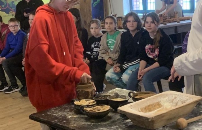 19 maja uczniowie klas 5a i 5b odwiedzili rodzinne miasto Mikołaja Kopernika. Zwiedzanie Torunia rozpoczęliśmy od Krzywej Wieży. Tutaj mogliśmy sprawdzić naszą prawość i uczciwość, gdyż według legendy tylko człowiek bez grzechu może utrzymać równowagę opierając się o jej ścianę. Następnie pan przewodnik oprowadził nas po Starym Mieście. Zobaczyliśmy dom i pomnik Mikołaja Kopernika, podziwialiśmy gotyckie kamienice, Bramę Klasztorną, Ratusz Staromiejski, Katedrę św. Jana Chrzciciela i św. Jana Ewangelisty. Poznaliśmy historię miasta i losy Mikołaja Kopernika. 
Kolejnym punktem programu było Żywe Muzeum Piernika. Pod okiem mistrza Dawida poznaliśmy rytuały związane z wypiekiem piernika. Własnoręcznie przygotowaliśmy ciasto i przy użyciu drewnianych form upiekliśmy pierniczki. Po warsztatach mieliśmy okazję zobaczyć manufakturę z początku XX wieku, maszyny służące do wypieku piernika, zabytkowy piec oraz kolekcję form woskowych.
Ostatnią atrakcją był Dom Legend Toruńskich. Tutaj nie tylko wysłuchaliśmy legend związanych z miastem, ale również sami mogliśmy wcielić się w ich bohaterów.
W drodze powrotnej zajechaliśmy do Grudziądza. Przeszliśmy Bramą Wodną na Stare Miasto i zrobiliśmy pamiątkową fotografię pod pomnikiem ułana i dziewczyny. 
To był udany dzień, pełen wrażeń. 