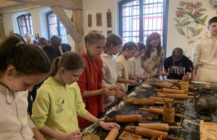 19 maja uczniowie klas 5a i 5b odwiedzili rodzinne miasto Mikołaja Kopernika. Zwiedzanie Torunia rozpoczęliśmy od Krzywej Wieży. Tutaj mogliśmy sprawdzić naszą prawość i uczciwość, gdyż według legendy tylko człowiek bez grzechu może utrzymać równowagę opierając się o jej ścianę. Następnie pan przewodnik oprowadził nas po Starym Mieście. Zobaczyliśmy dom i pomnik Mikołaja Kopernika, podziwialiśmy gotyckie kamienice, Bramę Klasztorną, Ratusz Staromiejski, Katedrę św. Jana Chrzciciela i św. Jana Ewangelisty. Poznaliśmy historię miasta i losy Mikołaja Kopernika. 
Kolejnym punktem programu było Żywe Muzeum Piernika. Pod okiem mistrza Dawida poznaliśmy rytuały związane z wypiekiem piernika. Własnoręcznie przygotowaliśmy ciasto i przy użyciu drewnianych form upiekliśmy pierniczki. Po warsztatach mieliśmy okazję zobaczyć manufakturę z początku XX wieku, maszyny służące do wypieku piernika, zabytkowy piec oraz kolekcję form woskowych.
Ostatnią atrakcją był Dom Legend Toruńskich. Tutaj nie tylko wysłuchaliśmy legend związanych z miastem, ale również sami mogliśmy wcielić się w ich bohaterów.
W drodze powrotnej zajechaliśmy do Grudziądza. Przeszliśmy Bramą Wodną na Stare Miasto i zrobiliśmy pamiątkową fotografię pod pomnikiem ułana i dziewczyny. 
To był udany dzień, pełen wrażeń. 