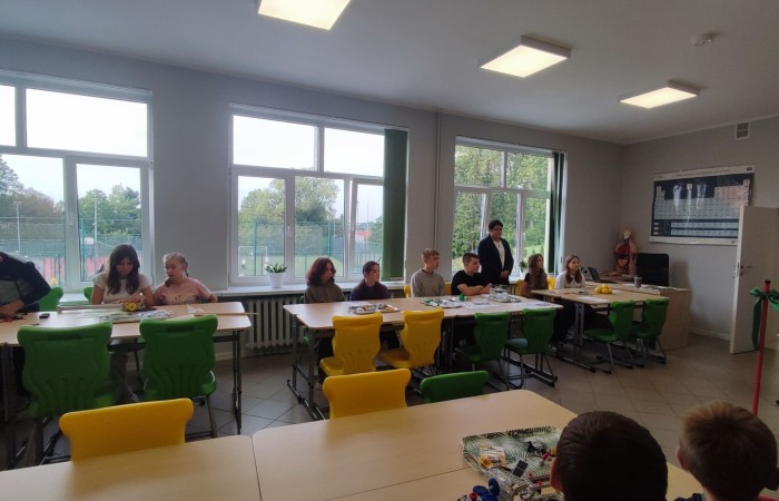 11 października 2023 r. w naszej szkole uroczyście otwarto ekopracownię - salę lekcyjną wraz z zapleczem, przeznaczoną do prowadzenia zajęć o charakterze przyrodniczo - ekologicznym oraz zajęć fizyki, chemii i biologii. W uroczystości udział wzięli zaproszeni goście: Wiceburmistrz Pasłęka Marek Sarnowski, kierownik Elbląskiego Centrum Edukacji Ekologicznej dr inź. Krzysztof Błaszczak oraz przewodnicząca Rady Rodziców - pani Anna Szymanek. Po powitaniu przez dyrektor szkoły Agnieszkę Cieklińską i przecięciu wstęgi goście mieli możliwość obserwowania zajęć z udziałem uczniów z kl.7a. Podopieczni nauczycielek chemii i fizyki, pani Doroty Andrzejewicz i pani Iwony Żabickiej wykonywali eksperymenty z wykorzystaniem pomocy dydaktycznych zakupionych w ramach projektu, związanych z OZE. Budowali m.in. baterię z owoców, minielektrownię wodną, układali z klocków model elektrowni wiatrowej oraz samochód napędzany energią słoneczną. 