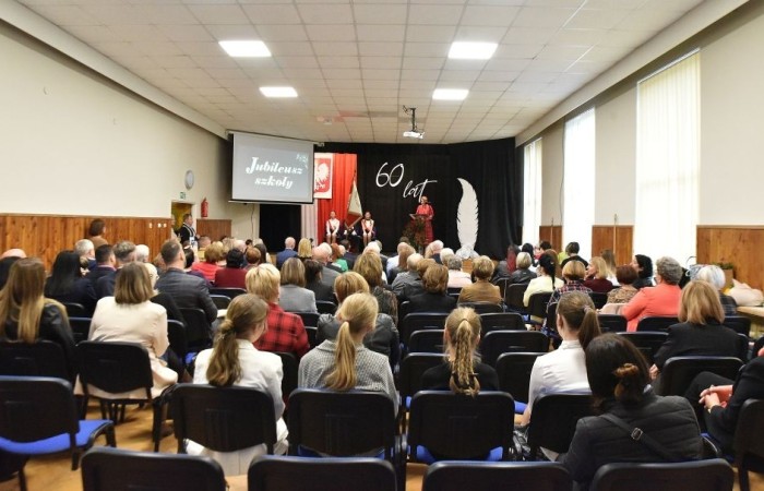 20 października świętowaliśmy Jubileusz 60-lecia Szkoły Podstawowej nr 2 w Pasłęku. Był to dla nas szczególny dzień, czas, w którym w symboliczny sposób przenieśliśmy się do chwili powstania naszej szkoły. Cieszymy się bardzo, że tak ważne dla nas wydarzenie swą obecnością uświetnili: minister Andrzej Śliwka - podsekretarz stanu w Ministerstwie Aktywów Państwowych, Burmistrz Pasłęka Pan Wiesław Śniecikowski, Przewodniczący Rady Miejskiej w Pasłęku Pan Marian Matuszczak, Starosta Powiatu Elbląskiego Pan Maciej Romanowski, wiceburmistrz Pan Marek Sarnowski, dyrektorzy i przedstawiciele instytucji oświatowych, służb mundurowych, działacze stowarzyszeń i związków zawodowych, emeryci oraz liczni absolwenci Szkoły Podstawowej nr 2 w Pasłęku.
Obchody jubileuszu rozpoczęliśmy od posadzenia drzewka przed pomnikiem patrona, Władysława Broniewskiego i przecięcia wstęgi na ławeczce upamiętniającej tę wyjątkową rocznicę. Następnie, już w auli, głos zabrała Pani Dyrektor Agnieszka Cieklińska, dzięki której wspomnienia związane z historią szkoły na nowo odżyły w pamięci zebranych. W pięknych słowach usłyszeliśmy o początkach szkoły, przypomnieliśmy sobie losy ludzi z nią związanych, ich sukcesy i zmagania, dzięki którym my dzisiaj możemy być częścią wyjątkowego miejsca, tak mocno wpisującego się w historię naszego miasta.
