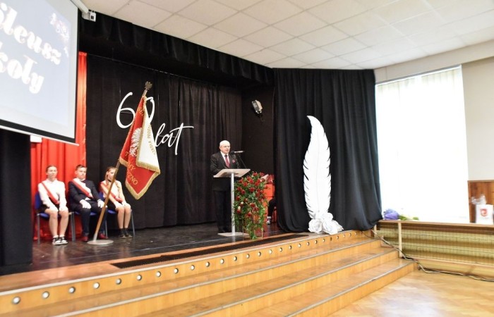 20 października świętowaliśmy Jubileusz 60-lecia Szkoły Podstawowej nr 2 w Pasłęku. Był to dla nas szczególny dzień, czas, w którym w symboliczny sposób przenieśliśmy się do chwili powstania naszej szkoły. Cieszymy się bardzo, że tak ważne dla nas wydarzenie swą obecnością uświetnili: minister Andrzej Śliwka - podsekretarz stanu w Ministerstwie Aktywów Państwowych, Burmistrz Pasłęka Pan Wiesław Śniecikowski, Przewodniczący Rady Miejskiej w Pasłęku Pan Marian Matuszczak, Starosta Powiatu Elbląskiego Pan Maciej Romanowski, wiceburmistrz Pan Marek Sarnowski, dyrektorzy i przedstawiciele instytucji oświatowych, służb mundurowych, działacze stowarzyszeń i związków zawodowych, emeryci oraz liczni absolwenci Szkoły Podstawowej nr 2 w Pasłęku.
Obchody jubileuszu rozpoczęliśmy od posadzenia drzewka przed pomnikiem patrona, Władysława Broniewskiego i przecięcia wstęgi na ławeczce upamiętniającej tę wyjątkową rocznicę. Następnie, już w auli, głos zabrała Pani Dyrektor Agnieszka Cieklińska, dzięki której wspomnienia związane z historią szkoły na nowo odżyły w pamięci zebranych. W pięknych słowach usłyszeliśmy o początkach szkoły, przypomnieliśmy sobie losy ludzi z nią związanych, ich sukcesy i zmagania, dzięki którym my dzisiaj możemy być częścią wyjątkowego miejsca, tak mocno wpisującego się w historię naszego miasta.