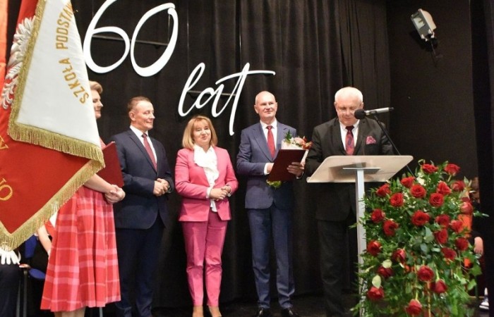 20 października świętowaliśmy Jubileusz 60-lecia Szkoły Podstawowej nr 2 w Pasłęku. Był to dla nas szczególny dzień, czas, w którym w symboliczny sposób przenieśliśmy się do chwili powstania naszej szkoły. Cieszymy się bardzo, że tak ważne dla nas wydarzenie swą obecnością uświetnili: minister Andrzej Śliwka - podsekretarz stanu w Ministerstwie Aktywów Państwowych, Burmistrz Pasłęka Pan Wiesław Śniecikowski, Przewodniczący Rady Miejskiej w Pasłęku Pan Marian Matuszczak, Starosta Powiatu Elbląskiego Pan Maciej Romanowski, wiceburmistrz Pan Marek Sarnowski, dyrektorzy i przedstawiciele instytucji oświatowych, służb mundurowych, działacze stowarzyszeń i związków zawodowych, emeryci oraz liczni absolwenci Szkoły Podstawowej nr 2 w Pasłęku.
Obchody jubileuszu rozpoczęliśmy od posadzenia drzewka przed pomnikiem patrona, Władysława Broniewskiego i przecięcia wstęgi na ławeczce upamiętniającej tę wyjątkową rocznicę. Następnie, już w auli, głos zabrała Pani Dyrektor Agnieszka Cieklińska, dzięki której wspomnienia związane z historią szkoły na nowo odżyły w pamięci zebranych. W pięknych słowach usłyszeliśmy o początkach szkoły, przypomnieliśmy sobie losy ludzi z nią związanych, ich sukcesy i zmagania, dzięki którym my dzisiaj możemy być częścią wyjątkowego miejsca, tak mocno wpisującego się w historię naszego miasta.