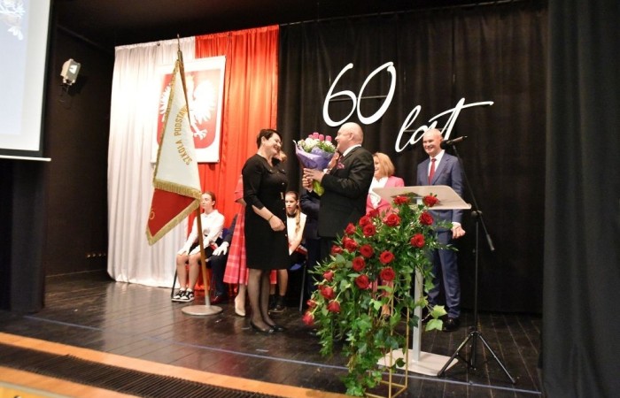 20 października świętowaliśmy Jubileusz 60-lecia Szkoły Podstawowej nr 2 w Pasłęku. Był to dla nas szczególny dzień, czas, w którym w symboliczny sposób przenieśliśmy się do chwili powstania naszej szkoły. Cieszymy się bardzo, że tak ważne dla nas wydarzenie swą obecnością uświetnili: minister Andrzej Śliwka - podsekretarz stanu w Ministerstwie Aktywów Państwowych, Burmistrz Pasłęka Pan Wiesław Śniecikowski, Przewodniczący Rady Miejskiej w Pasłęku Pan Marian Matuszczak, Starosta Powiatu Elbląskiego Pan Maciej Romanowski, wiceburmistrz Pan Marek Sarnowski, dyrektorzy i przedstawiciele instytucji oświatowych, służb mundurowych, działacze stowarzyszeń i związków zawodowych, emeryci oraz liczni absolwenci Szkoły Podstawowej nr 2 w Pasłęku.
Obchody jubileuszu rozpoczęliśmy od posadzenia drzewka przed pomnikiem patrona, Władysława Broniewskiego i przecięcia wstęgi na ławeczce upamiętniającej tę wyjątkową rocznicę. Następnie, już w auli, głos zabrała Pani Dyrektor Agnieszka Cieklińska, dzięki której wspomnienia związane z historią szkoły na nowo odżyły w pamięci zebranych. W pięknych słowach usłyszeliśmy o początkach szkoły, przypomnieliśmy sobie losy ludzi z nią związanych, ich sukcesy i zmagania, dzięki którym my dzisiaj możemy być częścią wyjątkowego miejsca, tak mocno wpisującego się w historię naszego miasta.