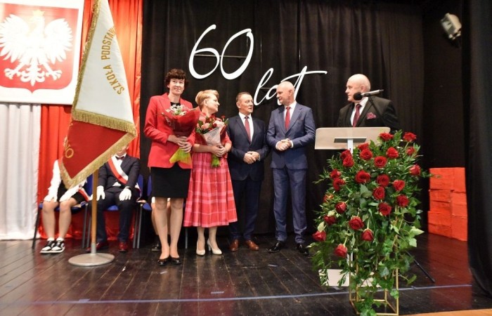 20 października świętowaliśmy Jubileusz 60-lecia Szkoły Podstawowej nr 2 w Pasłęku. Był to dla nas szczególny dzień, czas, w którym w symboliczny sposób przenieśliśmy się do chwili powstania naszej szkoły. Cieszymy się bardzo, że tak ważne dla nas wydarzenie swą obecnością uświetnili: minister Andrzej Śliwka - podsekretarz stanu w Ministerstwie Aktywów Państwowych, Burmistrz Pasłęka Pan Wiesław Śniecikowski, Przewodniczący Rady Miejskiej w Pasłęku Pan Marian Matuszczak, Starosta Powiatu Elbląskiego Pan Maciej Romanowski, wiceburmistrz Pan Marek Sarnowski, dyrektorzy i przedstawiciele instytucji oświatowych, służb mundurowych, działacze stowarzyszeń i związków zawodowych, emeryci oraz liczni absolwenci Szkoły Podstawowej nr 2 w Pasłęku.
Obchody jubileuszu rozpoczęliśmy od posadzenia drzewka przed pomnikiem patrona, Władysława Broniewskiego i przecięcia wstęgi na ławeczce upamiętniającej tę wyjątkową rocznicę. Następnie, już w auli, głos zabrała Pani Dyrektor Agnieszka Cieklińska, dzięki której wspomnienia związane z historią szkoły na nowo odżyły w pamięci zebranych. W pięknych słowach usłyszeliśmy o początkach szkoły, przypomnieliśmy sobie losy ludzi z nią związanych, ich sukcesy i zmagania, dzięki którym my dzisiaj możemy być częścią wyjątkowego miejsca, tak mocno wpisującego się w historię naszego miasta.