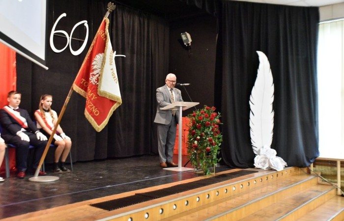 20 października świętowaliśmy Jubileusz 60-lecia Szkoły Podstawowej nr 2 w Pasłęku. Był to dla nas szczególny dzień, czas, w którym w symboliczny sposób przenieśliśmy się do chwili powstania naszej szkoły. Cieszymy się bardzo, że tak ważne dla nas wydarzenie swą obecnością uświetnili: minister Andrzej Śliwka - podsekretarz stanu w Ministerstwie Aktywów Państwowych, Burmistrz Pasłęka Pan Wiesław Śniecikowski, Przewodniczący Rady Miejskiej w Pasłęku Pan Marian Matuszczak, Starosta Powiatu Elbląskiego Pan Maciej Romanowski, wiceburmistrz Pan Marek Sarnowski, dyrektorzy i przedstawiciele instytucji oświatowych, służb mundurowych, działacze stowarzyszeń i związków zawodowych, emeryci oraz liczni absolwenci Szkoły Podstawowej nr 2 w Pasłęku.
Obchody jubileuszu rozpoczęliśmy od posadzenia drzewka przed pomnikiem patrona, Władysława Broniewskiego i przecięcia wstęgi na ławeczce upamiętniającej tę wyjątkową rocznicę. Następnie, już w auli, głos zabrała Pani Dyrektor Agnieszka Cieklińska, dzięki której wspomnienia związane z historią szkoły na nowo odżyły w pamięci zebranych. W pięknych słowach usłyszeliśmy o początkach szkoły, przypomnieliśmy sobie losy ludzi z nią związanych, ich sukcesy i zmagania, dzięki którym my dzisiaj możemy być częścią wyjątkowego miejsca, tak mocno wpisującego się w historię naszego miasta.