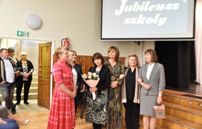 20 października świętowaliśmy Jubileusz 60-lecia Szkoły Podstawowej nr 2 w Pasłęku. Był to dla nas szczególny dzień, czas, w którym w symboliczny sposób przenieśliśmy się do chwili powstania naszej szkoły. Cieszymy się bardzo, że tak ważne dla nas wydarzenie swą obecnością uświetnili: minister Andrzej Śliwka - podsekretarz stanu w Ministerstwie Aktywów Państwowych, Burmistrz Pasłęka Pan Wiesław Śniecikowski, Przewodniczący Rady Miejskiej w Pasłęku Pan Marian Matuszczak, Starosta Powiatu Elbląskiego Pan Maciej Romanowski, wiceburmistrz Pan Marek Sarnowski, dyrektorzy i przedstawiciele instytucji oświatowych, służb mundurowych, działacze stowarzyszeń i związków zawodowych, emeryci oraz liczni absolwenci Szkoły Podstawowej nr 2 w Pasłęku.
Obchody jubileuszu rozpoczęliśmy od posadzenia drzewka przed pomnikiem patrona, Władysława Broniewskiego i przecięcia wstęgi na ławeczce upamiętniającej tę wyjątkową rocznicę. Następnie, już w auli, głos zabrała Pani Dyrektor Agnieszka Cieklińska, dzięki której wspomnienia związane z historią szkoły na nowo odżyły w pamięci zebranych. W pięknych słowach usłyszeliśmy o początkach szkoły, przypomnieliśmy sobie losy ludzi z nią związanych, ich sukcesy i zmagania, dzięki którym my dzisiaj możemy być częścią wyjątkowego miejsca, tak mocno wpisującego się w historię naszego miasta.