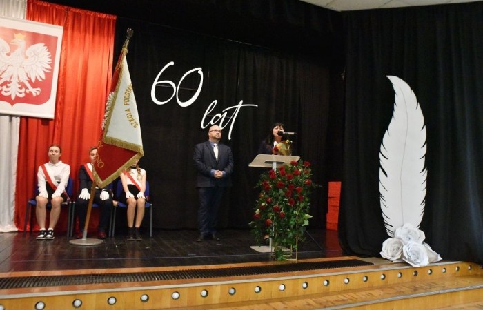 20 października świętowaliśmy Jubileusz 60-lecia Szkoły Podstawowej nr 2 w Pasłęku. Był to dla nas szczególny dzień, czas, w którym w symboliczny sposób przenieśliśmy się do chwili powstania naszej szkoły. Cieszymy się bardzo, że tak ważne dla nas wydarzenie swą obecnością uświetnili: minister Andrzej Śliwka - podsekretarz stanu w Ministerstwie Aktywów Państwowych, Burmistrz Pasłęka Pan Wiesław Śniecikowski, Przewodniczący Rady Miejskiej w Pasłęku Pan Marian Matuszczak, Starosta Powiatu Elbląskiego Pan Maciej Romanowski, wiceburmistrz Pan Marek Sarnowski, dyrektorzy i przedstawiciele instytucji oświatowych, służb mundurowych, działacze stowarzyszeń i związków zawodowych, emeryci oraz liczni absolwenci Szkoły Podstawowej nr 2 w Pasłęku.
Obchody jubileuszu rozpoczęliśmy od posadzenia drzewka przed pomnikiem patrona, Władysława Broniewskiego i przecięcia wstęgi na ławeczce upamiętniającej tę wyjątkową rocznicę. Następnie, już w auli, głos zabrała Pani Dyrektor Agnieszka Cieklińska, dzięki której wspomnienia związane z historią szkoły na nowo odżyły w pamięci zebranych. W pięknych słowach usłyszeliśmy o początkach szkoły, przypomnieliśmy sobie losy ludzi z nią związanych, ich sukcesy i zmagania, dzięki którym my dzisiaj możemy być częścią wyjątkowego miejsca, tak mocno wpisującego się w historię naszego miasta.
