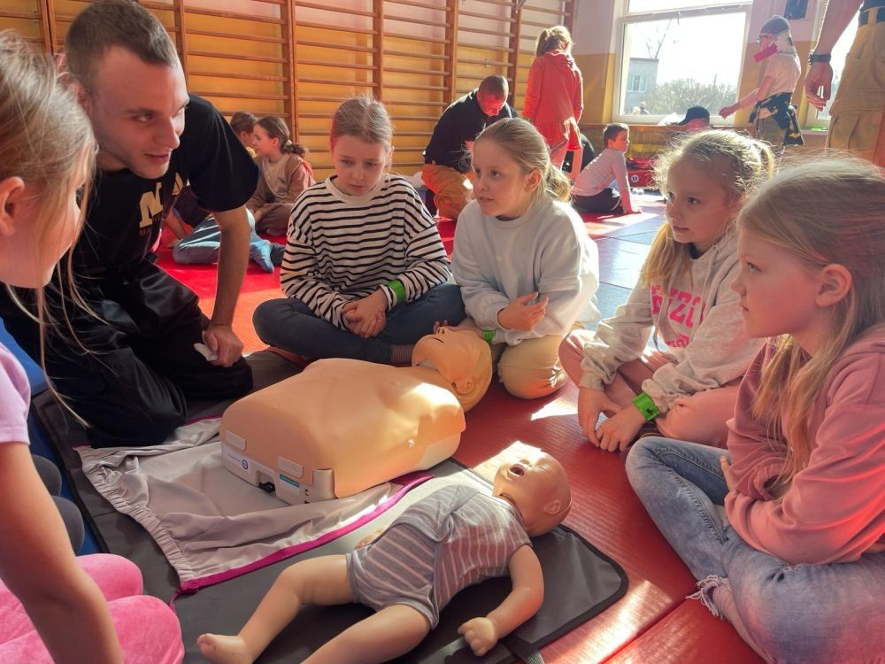 Wczoraj ponownie odwiedzili nas strażacy z OSP Marianka oraz JRG nr 3 w Pasłęku, którym towarzyszyły wolontariuszki z Zespołu Szkół w Pasłęku. Tym razem w spotkaniu uczestniczyli uczniowie klas drugich. Podczas szkolenia dzieci utrwaliły numer alarmowy 112, a także zapoznały się z całą procedurą zgłaszania wypadku i wzywania fachowej pomocy. Uczniowie dowiedzieli się co nieco na temat pracy strażaków, a także tego w jaki sposób opatruje się rany, złamania, udziela pierwszej pomocy, a co najważniejsze mieli okazję do przećwiczenia wszystkiego „na własnej skórze”. Jak widać po zdjęciach i tym razem dzieci były zachwycone. 
To była niezwykle istotna lekcja pomagająca poprzez zabawę i doświadczenia zdobywać nowe bardzo ważne informacje i umiejętności. 