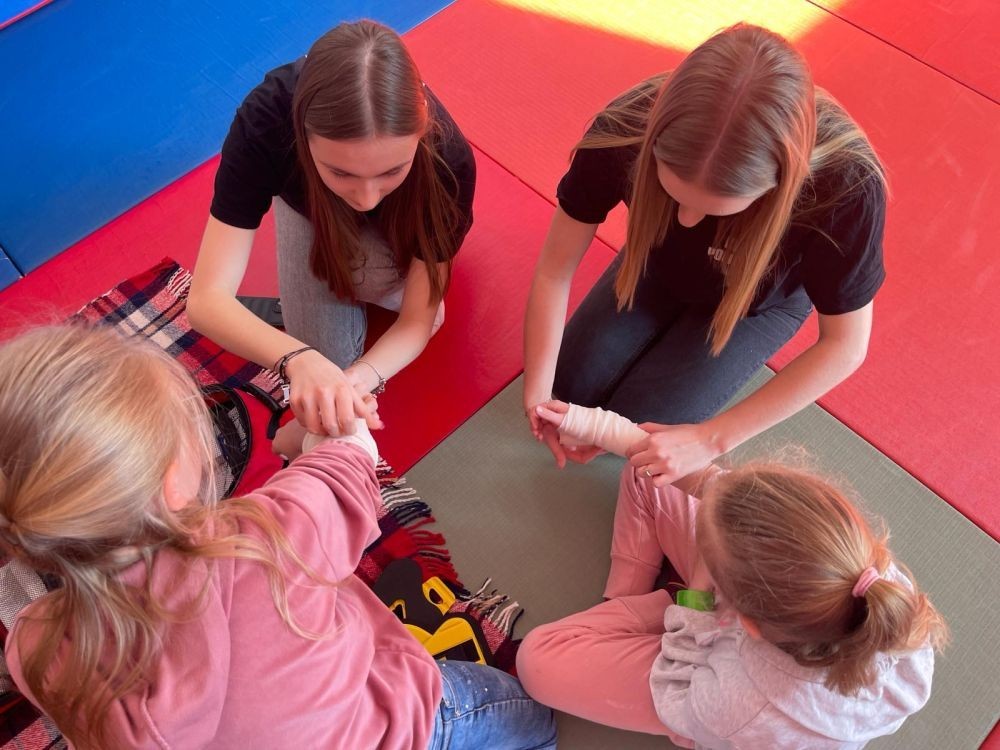 Wczoraj ponownie odwiedzili nas strażacy z OSP Marianka oraz JRG nr 3 w Pasłęku, którym towarzyszyły wolontariuszki z Zespołu Szkół w Pasłęku. Tym razem w spotkaniu uczestniczyli uczniowie klas drugich. Podczas szkolenia dzieci utrwaliły numer alarmowy 112, a także zapoznały się z całą procedurą zgłaszania wypadku i wzywania fachowej pomocy. Uczniowie dowiedzieli się co nieco na temat pracy strażaków, a także tego w jaki sposób opatruje się rany, złamania, udziela pierwszej pomocy, a co najważniejsze mieli okazję do przećwiczenia wszystkiego „na własnej skórze”. Jak widać po zdjęciach i tym razem dzieci były zachwycone. 
To była niezwykle istotna lekcja pomagająca poprzez zabawę i doświadczenia zdobywać nowe bardzo ważne informacje i umiejętności. 