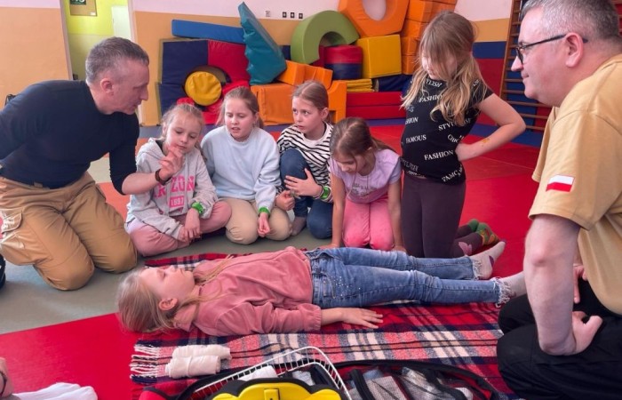 Wczoraj ponownie odwiedzili nas strażacy z OSP Marianka oraz JRG nr 3 w Pasłęku, którym towarzyszyły wolontariuszki z Zespołu Szkół w Pasłęku. Tym razem w spotkaniu uczestniczyli uczniowie klas drugich. Podczas szkolenia dzieci utrwaliły numer alarmowy 112, a także zapoznały się z całą procedurą zgłaszania wypadku i wzywania fachowej pomocy. Uczniowie dowiedzieli się co nieco na temat pracy strażaków, a także tego w jaki sposób opatruje się rany, złamania, udziela pierwszej pomocy, a co najważniejsze mieli okazję do przećwiczenia wszystkiego „na własnej skórze”. Jak widać po zdjęciach i tym razem dzieci były zachwycone. 
To była niezwykle istotna lekcja pomagająca poprzez zabawę i doświadczenia zdobywać nowe bardzo ważne informacje i umiejętności. 