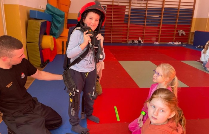 Wczoraj ponownie odwiedzili nas strażacy z OSP Marianka oraz JRG nr 3 w Pasłęku, którym towarzyszyły wolontariuszki z Zespołu Szkół w Pasłęku. Tym razem w spotkaniu uczestniczyli uczniowie klas drugich. Podczas szkolenia dzieci utrwaliły numer alarmowy 112, a także zapoznały się z całą procedurą zgłaszania wypadku i wzywania fachowej pomocy. Uczniowie dowiedzieli się co nieco na temat pracy strażaków, a także tego w jaki sposób opatruje się rany, złamania, udziela pierwszej pomocy, a co najważniejsze mieli okazję do przećwiczenia wszystkiego „na własnej skórze”. Jak widać po zdjęciach i tym razem dzieci były zachwycone. 
To była niezwykle istotna lekcja pomagająca poprzez zabawę i doświadczenia zdobywać nowe bardzo ważne informacje i umiejętności. 