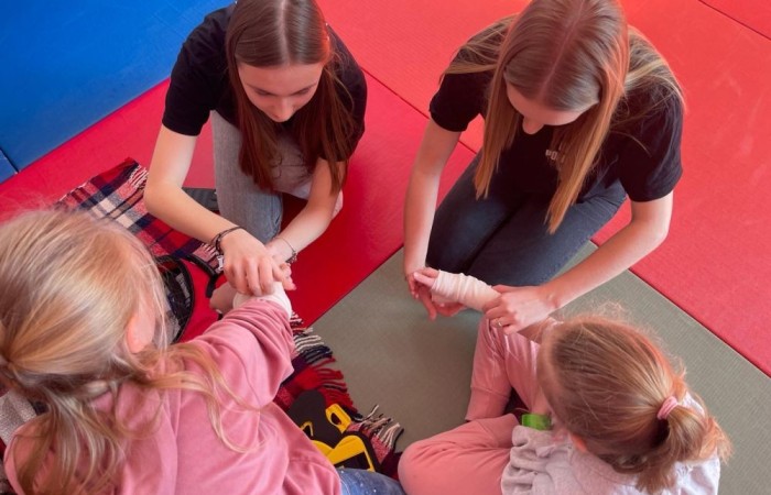 Wczoraj ponownie odwiedzili nas strażacy z OSP Marianka oraz JRG nr 3 w Pasłęku, którym towarzyszyły wolontariuszki z Zespołu Szkół w Pasłęku. Tym razem w spotkaniu uczestniczyli uczniowie klas drugich. Podczas szkolenia dzieci utrwaliły numer alarmowy 112, a także zapoznały się z całą procedurą zgłaszania wypadku i wzywania fachowej pomocy. Uczniowie dowiedzieli się co nieco na temat pracy strażaków, a także tego w jaki sposób opatruje się rany, złamania, udziela pierwszej pomocy, a co najważniejsze mieli okazję do przećwiczenia wszystkiego „na własnej skórze”. Jak widać po zdjęciach i tym razem dzieci były zachwycone. 
To była niezwykle istotna lekcja pomagająca poprzez zabawę i doświadczenia zdobywać nowe bardzo ważne informacje i umiejętności. 