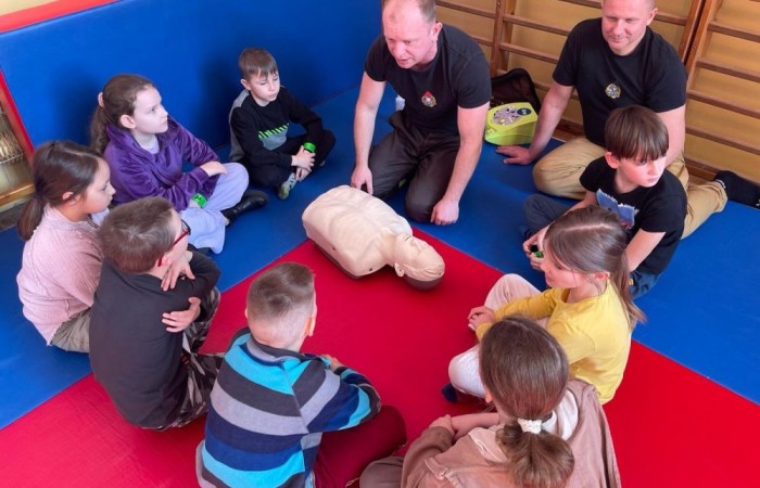 Wczoraj ponownie odwiedzili nas strażacy z OSP Marianka oraz JRG nr 3 w Pasłęku, którym towarzyszyły wolontariuszki z Zespołu Szkół w Pasłęku. Tym razem w spotkaniu uczestniczyli uczniowie klas drugich. Podczas szkolenia dzieci utrwaliły numer alarmowy 112, a także zapoznały się z całą procedurą zgłaszania wypadku i wzywania fachowej pomocy. Uczniowie dowiedzieli się co nieco na temat pracy strażaków, a także tego w jaki sposób opatruje się rany, złamania, udziela pierwszej pomocy, a co najważniejsze mieli okazję do przećwiczenia wszystkiego „na własnej skórze”. Jak widać po zdjęciach i tym razem dzieci były zachwycone. 
To była niezwykle istotna lekcja pomagająca poprzez zabawę i doświadczenia zdobywać nowe bardzo ważne informacje i umiejętności. 