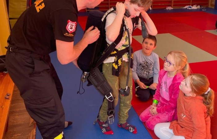 Wczoraj ponownie odwiedzili nas strażacy z OSP Marianka oraz JRG nr 3 w Pasłęku, którym towarzyszyły wolontariuszki z Zespołu Szkół w Pasłęku. Tym razem w spotkaniu uczestniczyli uczniowie klas drugich. Podczas szkolenia dzieci utrwaliły numer alarmowy 112, a także zapoznały się z całą procedurą zgłaszania wypadku i wzywania fachowej pomocy. Uczniowie dowiedzieli się co nieco na temat pracy strażaków, a także tego w jaki sposób opatruje się rany, złamania, udziela pierwszej pomocy, a co najważniejsze mieli okazję do przećwiczenia wszystkiego „na własnej skórze”. Jak widać po zdjęciach i tym razem dzieci były zachwycone. 
To była niezwykle istotna lekcja pomagająca poprzez zabawę i doświadczenia zdobywać nowe bardzo ważne informacje i umiejętności. 