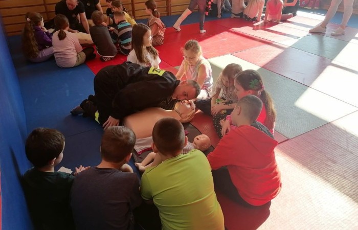 Wczoraj ponownie odwiedzili nas strażacy z OSP Marianka oraz JRG nr 3 w Pasłęku, którym towarzyszyły wolontariuszki z Zespołu Szkół w Pasłęku. Tym razem w spotkaniu uczestniczyli uczniowie klas drugich. Podczas szkolenia dzieci utrwaliły numer alarmowy 112, a także zapoznały się z całą procedurą zgłaszania wypadku i wzywania fachowej pomocy. Uczniowie dowiedzieli się co nieco na temat pracy strażaków, a także tego w jaki sposób opatruje się rany, złamania, udziela pierwszej pomocy, a co najważniejsze mieli okazję do przećwiczenia wszystkiego „na własnej skórze”. Jak widać po zdjęciach i tym razem dzieci były zachwycone. 
To była niezwykle istotna lekcja pomagająca poprzez zabawę i doświadczenia zdobywać nowe bardzo ważne informacje i umiejętności. 