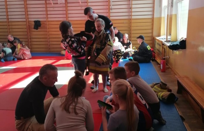 Wczoraj ponownie odwiedzili nas strażacy z OSP Marianka oraz JRG nr 3 w Pasłęku, którym towarzyszyły wolontariuszki z Zespołu Szkół w Pasłęku. Tym razem w spotkaniu uczestniczyli uczniowie klas drugich. Podczas szkolenia dzieci utrwaliły numer alarmowy 112, a także zapoznały się z całą procedurą zgłaszania wypadku i wzywania fachowej pomocy. Uczniowie dowiedzieli się co nieco na temat pracy strażaków, a także tego w jaki sposób opatruje się rany, złamania, udziela pierwszej pomocy, a co najważniejsze mieli okazję do przećwiczenia wszystkiego „na własnej skórze”. Jak widać po zdjęciach i tym razem dzieci były zachwycone. 
To była niezwykle istotna lekcja pomagająca poprzez zabawę i doświadczenia zdobywać nowe bardzo ważne informacje i umiejętności. 