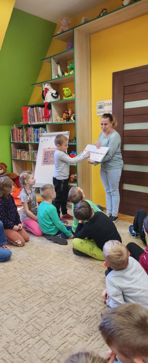 W dniu 7 maja dzieci z grupy „Biedronki „ udały się na lekcję biblioteczną do Biblioteki Publicznej w Pasłęku. Dla wielu z nich była to pierwsza wizyta w takim miejscu. Przedszkolaki zwiedziły bibliotekę, dowiedziały się jaka jest różnica między biblioteką a księgarnią oraz  co należy zrobić, aby stać się czytelnikiem biblioteki. Poznały również zasady właściwego zachowania się w bibliotece oraz czytelni. Dzieci uczestniczyły w lekcji bibliotecznej, podczas której zostały zapoznane ze sposobem powstawania książki. Podczas spotkania zaprezentowana została również literatura dziecięca, którą dzieci mogły swobodnie obejrzeć podczas zabawy. Dużym zainteresowaniem dzieci cieszyło się zwiedzanie Izby Historycznej, w której to miały możliwość zapoznania się z  przedmiotami używanymi  w dawnych czasach. Ku ich zaskoczeniu  zupełnie inaczej kiedyś wyglądało żelazko oraz gofrownica. Na koniec spotkania dzieci miały możliwość pobawienia się zabawkami oraz przemaszerowania się między regałami w celu obejrzenia książeczek. Żegnając się z panią bibliotekarką dzieci zapewniły, że ponownie odwiedzą to ciekawe miejsce razem z rodzicami, by zapisać się do biblioteki i wypożyczać interesujące książki albo po prostu pograć w „planszówki” i miło spędzić  czas.
Bardzo dziękujemy za wspaniała lekcję :)