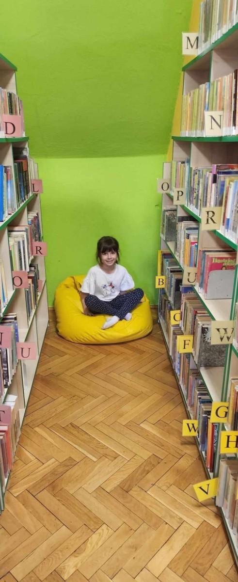 W dniu 7 maja dzieci z grupy „Biedronki „ udały się na lekcję biblioteczną do Biblioteki Publicznej w Pasłęku. Dla wielu z nich była to pierwsza wizyta w takim miejscu. Przedszkolaki zwiedziły bibliotekę, dowiedziały się jaka jest różnica między biblioteką a księgarnią oraz  co należy zrobić, aby stać się czytelnikiem biblioteki. Poznały również zasady właściwego zachowania się w bibliotece oraz czytelni. Dzieci uczestniczyły w lekcji bibliotecznej, podczas której zostały zapoznane ze sposobem powstawania książki. Podczas spotkania zaprezentowana została również literatura dziecięca, którą dzieci mogły swobodnie obejrzeć podczas zabawy. Dużym zainteresowaniem dzieci cieszyło się zwiedzanie Izby Historycznej, w której to miały możliwość zapoznania się z  przedmiotami używanymi  w dawnych czasach. Ku ich zaskoczeniu  zupełnie inaczej kiedyś wyglądało żelazko oraz gofrownica. Na koniec spotkania dzieci miały możliwość pobawienia się zabawkami oraz przemaszerowania się między regałami w celu obejrzenia książeczek. Żegnając się z panią bibliotekarką dzieci zapewniły, że ponownie odwiedzą to ciekawe miejsce razem z rodzicami, by zapisać się do biblioteki i wypożyczać interesujące książki albo po prostu pograć w „planszówki” i miło spędzić  czas.
Bardzo dziękujemy za wspaniała lekcję :)