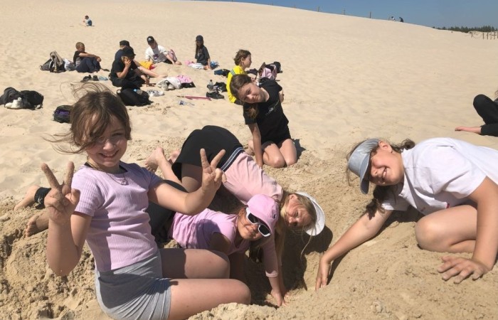 W dniach 15-18 maja 2024 roku uczniowie klas 4A i 5B wybrali się na wycieczkę do Łeby. Oto krótkie podsumowanie ich przygody.
Wizyta w Słowińskim Parku Narodowym była niezapomniana. Ruchome wydmy to unikalne miejsce, gdzie piaskowe pagórki przemieszczają się pod wpływem wiatru. Uczniowie mieli okazję spacerować po tych wydmach i podziwiać piękno natury.
W Łebie Parku czekało na nich wiele atrakcji: Zamek Strachu - dla odważnych, którzy lubią emocje; pojazdy Flinstonów - ciekawa atrakcja dla fanów kultowego serialu, Kopalnia złota - poszukiwanie skarbów; Labirynt magicznych luster - złudzenie nieskończonego lustra; zjeżdżalnie wodne 4 w 1 oraz zjeżdżalnia Boomerang - dla fanów wodnych atrakcji, zjazd na pontonach bez potrzeby przebierania się w stroje kąpielowe, wysokość ślizgu – 10 metrów; Diabelski Młyn, wysoki na 27 metrów wyposażony w 20 gondoli stoi nieopodal naszych zjeżdżalni, widok z góry zapiera dech w piersiach; park trampolin - ogromna przestrzeń, wypełniona parkourem, trampolinami, koszykówką, a także miejscem do robienia salt,  po których bezpiecznie wylądujesz na poduchę; autodrom - atrakcja którą zna niemal każdy! To must-have każdego parku rozrywki.
Uczniowie przemieszczali się po Łebie na melexach, co było wygodnym i ekscytującym środkiem transportu. Na koniec dnia uczniowie odpoczywali w Ośrodku Wypoczynkowym Fregata, gdzie mogli zrelaksować się po pełnym wrażeń dniu.
Wycieczka była udana, a uczniowie wrócili do domu z pięknymi wspomnieniami!