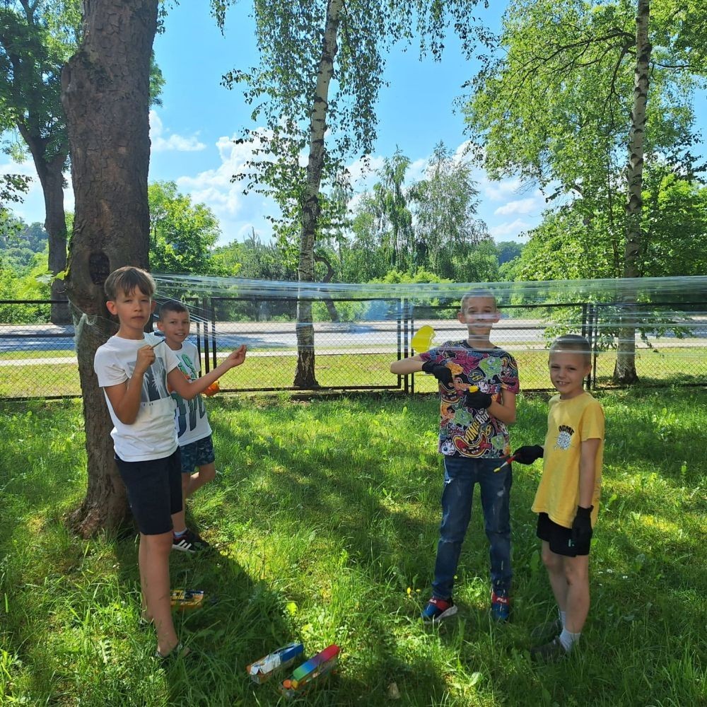 W ostatnim czasie uczniowie klasy III b wzięli udział w wyjątkowych zajęciach plastycznych, które wprawiły ich w zachwyt i radość tworzenia. Tym razem nasze artystyczne dusze miały okazję malować na świeżym powietrzu. Wyjątkowy pomysł na wykorzystanie folii spożywczej rozciągniętej pomiędzy drzewami okazał się strzałem w dziesiątkę. Uczniowie mogli wyrażać swoją kreatywność, eksperymentować z kolorami i formami, czerpiąc inspirację z natury otaczającej naszą szkołę.