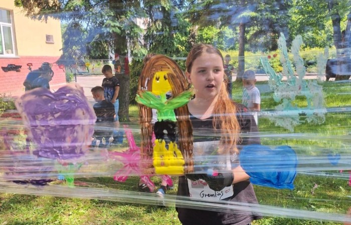 W ostatnim czasie uczniowie klasy III b wzięli udział w wyjątkowych zajęciach plastycznych, które wprawiły ich w zachwyt i radość tworzenia. Tym razem nasze artystyczne dusze miały okazję malować na świeżym powietrzu. Wyjątkowy pomysł na wykorzystanie folii spożywczej rozciągniętej pomiędzy drzewami okazał się strzałem w dziesiątkę. Uczniowie mogli wyrażać swoją kreatywność, eksperymentować z kolorami i formami, czerpiąc inspirację z natury otaczającej naszą szkołę.