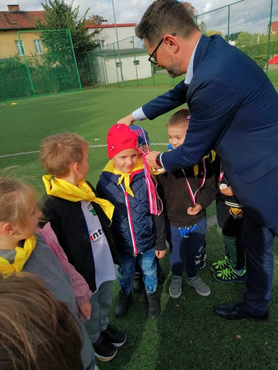 Starszaki z naszego Przedszkola miały możliwość uczestniczenia w Igrzyskach Przedszkolaków które odbyły się  dnia 27.09 na boisku sportowym przy Szkole Podstawowej nr 1. 
Zadania jakie miały wykonać dzieci to:
-bieg z pokonaniem tunelu
-bieg przez płotki
-przenoszenie piłki
-bieg slalomem
-strzały piłką na bramkę
Każda z grup konkurowała ze sobą z podziałem na Przedszkola. 
Ten dzień spędziliśmy pod wpływem pozytywnych emocji, mogliśmy wykazać się sportowo oraz zdobyć przy tym nagrody w postaci medali.