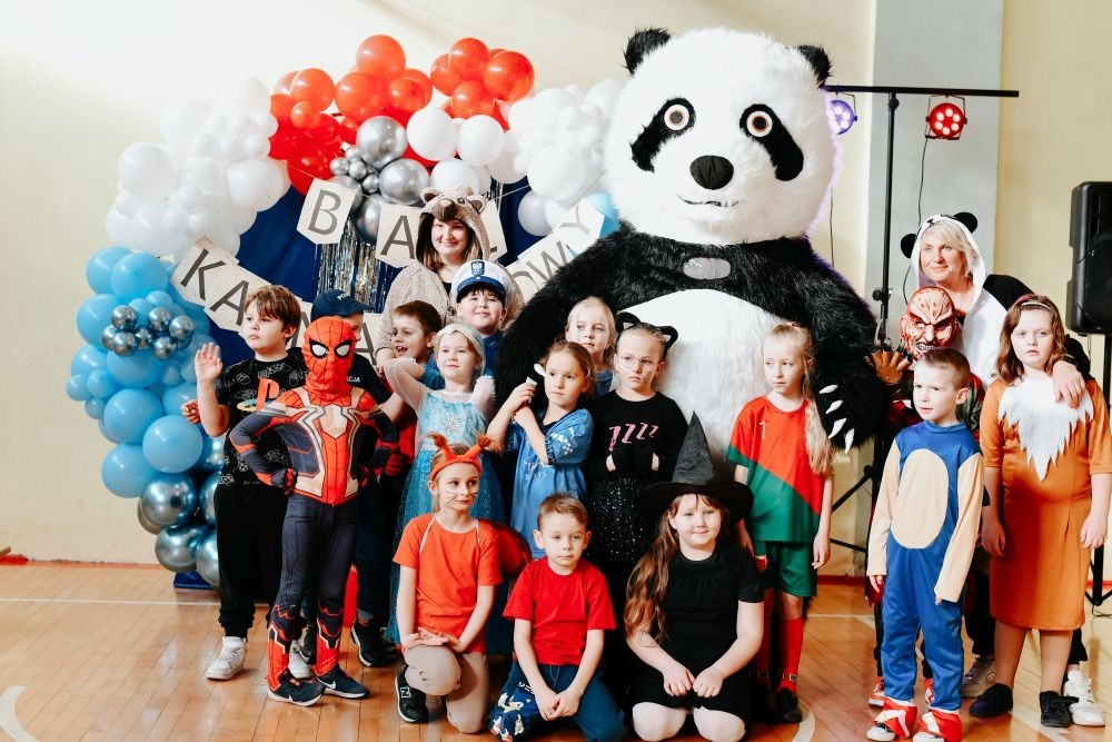 Uczniowie klas młodszych postanowili zakończyć pierwszy tydzień po feriach z prawdziwym rozmachem. Przebrani za bohaterów bajek i nie tylko, tłumnie ruszyli na salę gimnastyczną, która tego dnia zamieniła się w prawdziwą salę balową. 
O niezapomnianą atmosferę zadbał DJ Padre, który porwał wszystkich do tańca i sprawił, że parkiet nie miał ani chwili wytchnienia. Jednak największą niespodzianką była wizyta ogromnej, uroczej maskotki pandy – jej towarzystwo wywołało mnóstwo uśmiechów i radości.
To był dzień pełen zabawy, tańca i niezapomnianych wspomnień. Dziękujemy wszystkim za wspaniałą atmosferę i już nie możemy się doczekać kolejnych takich wydarzeń.
