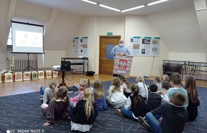 Dzieci z zerówki w bibliotece publicznej uczestniczyły w lekcji patriotyzmu przeprowadzonej przez dyrektora biblioteki p. Adamczyka. Lekcja przypomniała dzieciom symbole narodowe, poznały ciekawostki historyczne dotyczące pochodzenia tych symboli oraz ich znaczenia w historii Polski. Wspólnie odśpiewały fragment hymnu narodowego oraz wykonały flagę Polski.