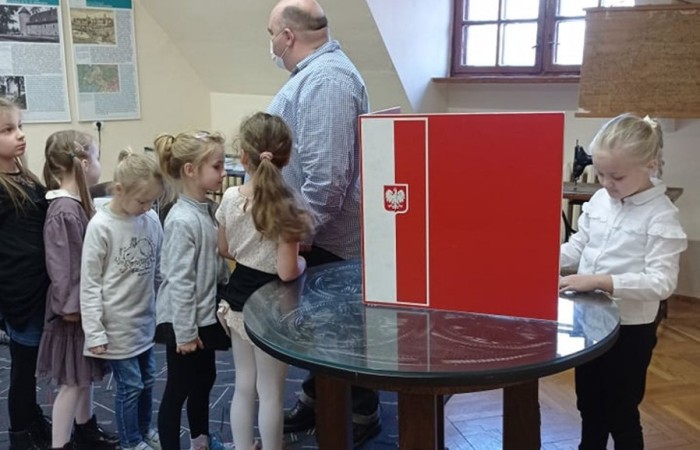 Dzieci z zerówki w bibliotece publicznej uczestniczyły w lekcji patriotyzmu przeprowadzonej przez dyrektora biblioteki p. Adamczyka. Lekcja przypomniała dzieciom symbole narodowe, poznały ciekawostki historyczne dotyczące pochodzenia tych symboli oraz ich znaczenia w historii Polski. Wspólnie odśpiewały fragment hymnu narodowego oraz wykonały flagę Polski.