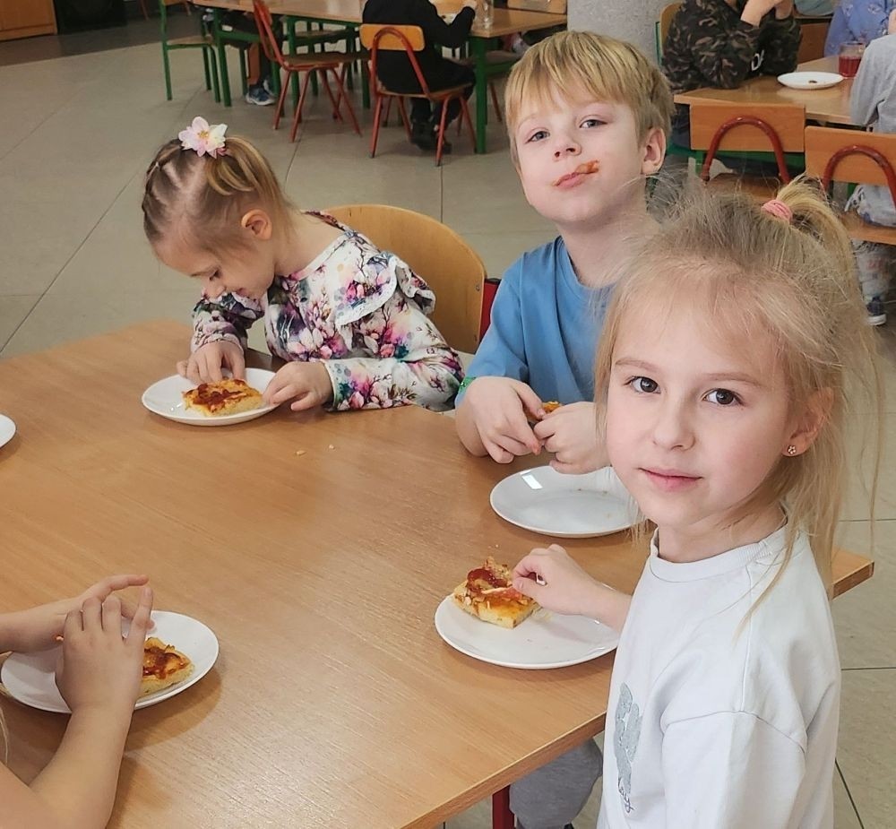 Pizza to ulubiona potrawa nie tylko dorosłych, ale także dzieci. Podczas zajęć przedszkolaki poznały krótką historię pizzy, dowiedziały się, z jakiego kraju pochodzi oraz poznały składniki, które są niezbędne do jej przygotowania. Dzieci w tym dniu miały możliwość komponowania swojej pizzy oraz wykonania jej kawałeczka używając do tego różnych materiałów plastycznych. Podsumowaniem tego pysznego dnia  była konsumpcja pizzy wykonanej przez nasze Panie kucharki. Zapach oregano rozchodził się po całym przedszkolu.
