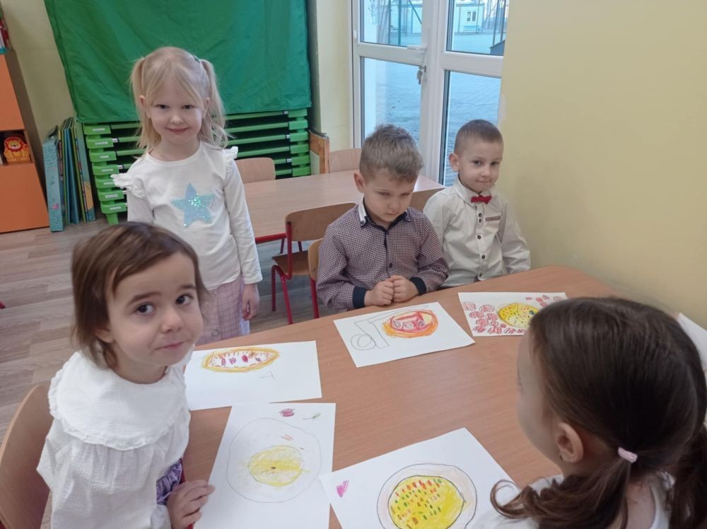 Pizza to ulubiona potrawa nie tylko dorosłych, ale także dzieci. Podczas zajęć przedszkolaki poznały krótką historię pizzy, dowiedziały się, z jakiego kraju pochodzi oraz poznały składniki, które są niezbędne do jej przygotowania. Dzieci w tym dniu miały możliwość komponowania swojej pizzy oraz wykonania jej kawałeczka używając do tego różnych materiałów plastycznych. Podsumowaniem tego pysznego dnia  była konsumpcja pizzy wykonanej przez nasze Panie kucharki. Zapach oregano rozchodził się po całym przedszkolu.
