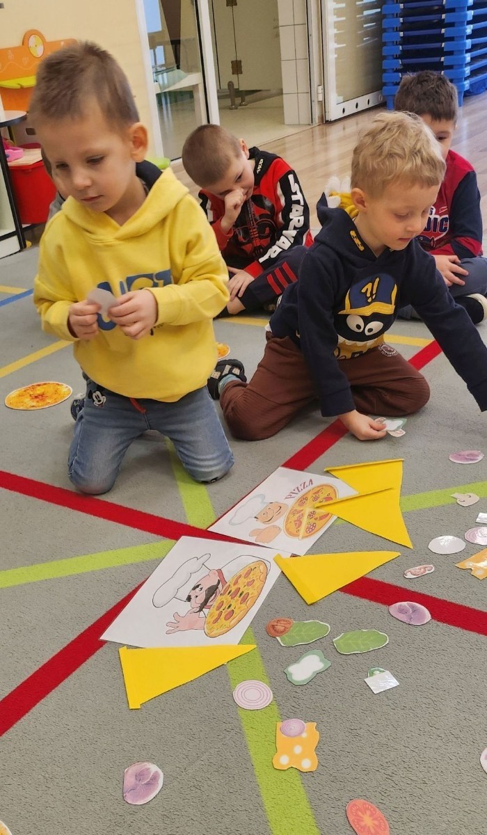 Pizza to ulubiona potrawa nie tylko dorosłych, ale także dzieci. Podczas zajęć przedszkolaki poznały krótką historię pizzy, dowiedziały się, z jakiego kraju pochodzi oraz poznały składniki, które są niezbędne do jej przygotowania. Dzieci w tym dniu miały możliwość komponowania swojej pizzy oraz wykonania jej kawałeczka używając do tego różnych materiałów plastycznych. Podsumowaniem tego pysznego dnia  była konsumpcja pizzy wykonanej przez nasze Panie kucharki. Zapach oregano rozchodził się po całym przedszkolu.

