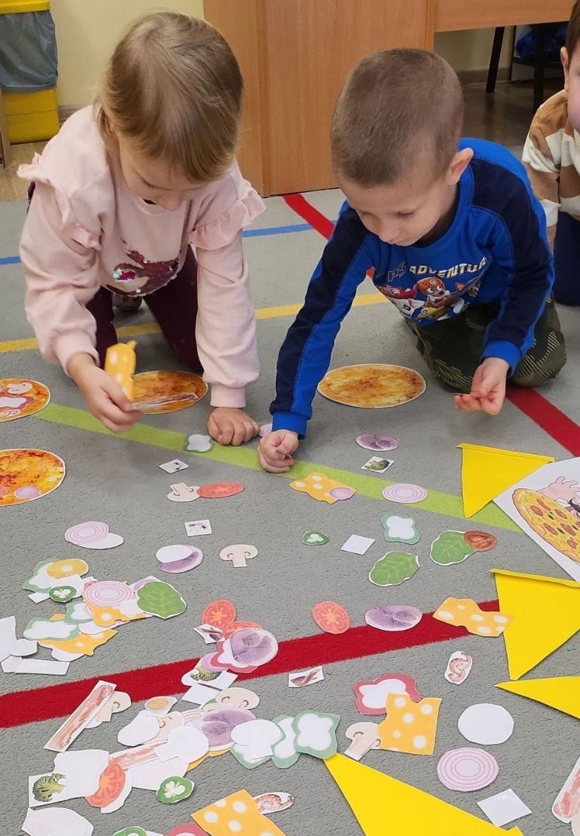 Pizza to ulubiona potrawa nie tylko dorosłych, ale także dzieci. Podczas zajęć przedszkolaki poznały krótką historię pizzy, dowiedziały się, z jakiego kraju pochodzi oraz poznały składniki, które są niezbędne do jej przygotowania. Dzieci w tym dniu miały możliwość komponowania swojej pizzy oraz wykonania jej kawałeczka używając do tego różnych materiałów plastycznych. Podsumowaniem tego pysznego dnia  była konsumpcja pizzy wykonanej przez nasze Panie kucharki. Zapach oregano rozchodził się po całym przedszkolu.
