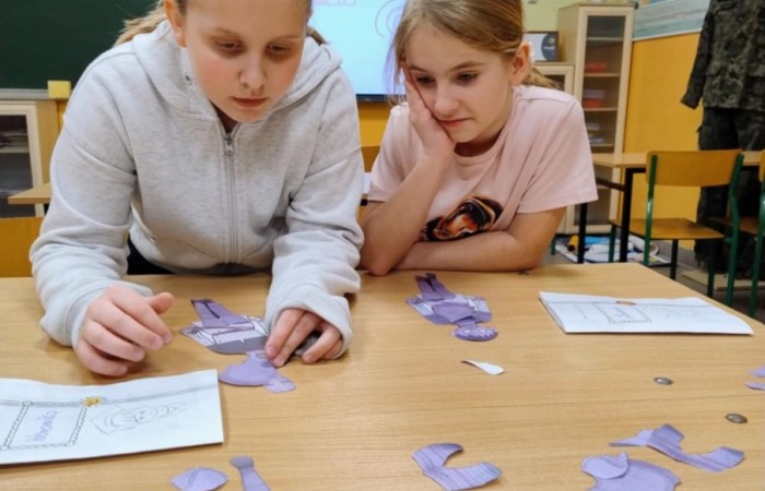 26 lutego w naszej szkole odbył się wyjątkowy DZIEŃ OTWARTY, podczas którego mieliśmy przyjemność gościć przedszkolaków, przyszłych uczniów oraz ich rodziców. Była to doskonała okazja, aby poczuć atmosferę naszej szkoły, poznać jej ofertę edukacyjną i odkryć to, co czyni ją miejscem pełnym pasji, wiedzy i radości.
Zwiedzanie naszej placówki obejmowało sale przedmiotowe, bibliotekę, stołówkę, świetlicę oraz małą salę gimnastyczną, gdzie można było na własnej skórze poczuć rytm codziennego życia naszej szkolnej społeczności.
Na odwiedzających czekało mnóstwo niespodzianek! Zachętą do działania były pieczątki, które najmłodsi otrzymywali w nagrodę za wykonanie przeróżnych zadań. W sali gimnastycznej na uczestników czekały ekscytujące konkurencje sprawnościowe, a w pracowni kulinarnej – pachnące i chrupiące gofry własnej roboty. Młodzi odkrywcy mieli okazję badać świat przez mikroskop, eksperymentować z interaktywnymi robotami Photon oraz brać udział w zajęciach z robotyki. Z kolei miłośnicy sztuki mogli tworzyć piękne dzieła na warsztatach plastycznych i origami, a najmłodsi cieszyli się malowaniem twarzy.
Nie zabrakło także wyzwań dla bystrego umysłu! Gry i zabawy językowe, rebusy oraz polonistyczne łamigłówki rozbudzały wyobraźnię i rozwijały umiejętności językowe. Wesoła „Gimnastyka buzi i języka” sprawiła, że ćwiczenie dykcji stało się czystą przyjemnością. Ogromnym zainteresowaniem cieszyły się również gry planszowe, które dostarczyły mnóstwa radości i emocjonującej rywalizacji. Dodatkowo, zabawy z chustą Klanza okazały się świetnym sposobem na integrację i wspólną zabawę pełną śmiechu.
Aktywne zwiedzanie stało się więc okazją do rozwijania ciekawości świata, nabywania nowych umiejętności, pobudzania w najmłodszych kreatywności oraz odczuwania satysfakcji z osiągniętego sukcesu.