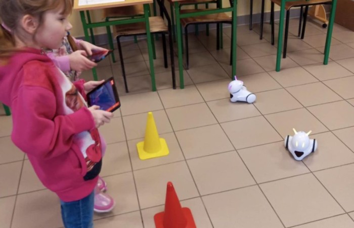 26 lutego w naszej szkole odbył się wyjątkowy DZIEŃ OTWARTY, podczas którego mieliśmy przyjemność gościć przedszkolaków, przyszłych uczniów oraz ich rodziców. Była to doskonała okazja, aby poczuć atmosferę naszej szkoły, poznać jej ofertę edukacyjną i odkryć to, co czyni ją miejscem pełnym pasji, wiedzy i radości.
Zwiedzanie naszej placówki obejmowało sale przedmiotowe, bibliotekę, stołówkę, świetlicę oraz małą salę gimnastyczną, gdzie można było na własnej skórze poczuć rytm codziennego życia naszej szkolnej społeczności.
Na odwiedzających czekało mnóstwo niespodzianek! Zachętą do działania były pieczątki, które najmłodsi otrzymywali w nagrodę za wykonanie przeróżnych zadań. W sali gimnastycznej na uczestników czekały ekscytujące konkurencje sprawnościowe, a w pracowni kulinarnej – pachnące i chrupiące gofry własnej roboty. Młodzi odkrywcy mieli okazję badać świat przez mikroskop, eksperymentować z interaktywnymi robotami Photon oraz brać udział w zajęciach z robotyki. Z kolei miłośnicy sztuki mogli tworzyć piękne dzieła na warsztatach plastycznych i origami, a najmłodsi cieszyli się malowaniem twarzy.
Nie zabrakło także wyzwań dla bystrego umysłu! Gry i zabawy językowe, rebusy oraz polonistyczne łamigłówki rozbudzały wyobraźnię i rozwijały umiejętności językowe. Wesoła „Gimnastyka buzi i języka” sprawiła, że ćwiczenie dykcji stało się czystą przyjemnością. Ogromnym zainteresowaniem cieszyły się również gry planszowe, które dostarczyły mnóstwa radości i emocjonującej rywalizacji. Dodatkowo, zabawy z chustą Klanza okazały się świetnym sposobem na integrację i wspólną zabawę pełną śmiechu.
Aktywne zwiedzanie stało się więc okazją do rozwijania ciekawości świata, nabywania nowych umiejętności, pobudzania w najmłodszych kreatywności oraz odczuwania satysfakcji z osiągniętego sukcesu.