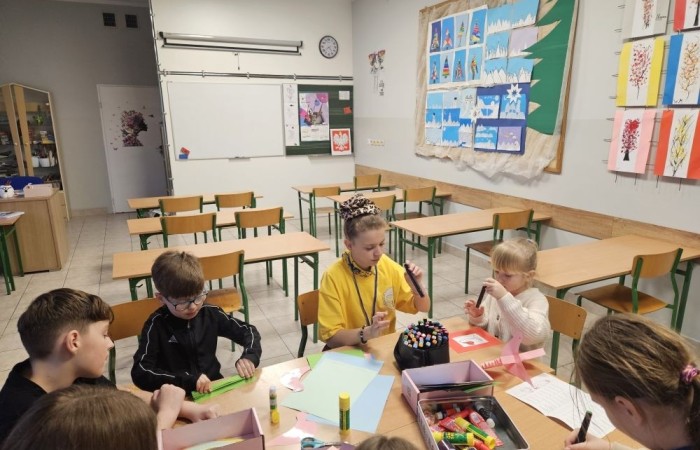 26 lutego w naszej szkole odbył się wyjątkowy DZIEŃ OTWARTY, podczas którego mieliśmy przyjemność gościć przedszkolaków, przyszłych uczniów oraz ich rodziców. Była to doskonała okazja, aby poczuć atmosferę naszej szkoły, poznać jej ofertę edukacyjną i odkryć to, co czyni ją miejscem pełnym pasji, wiedzy i radości.
Zwiedzanie naszej placówki obejmowało sale przedmiotowe, bibliotekę, stołówkę, świetlicę oraz małą salę gimnastyczną, gdzie można było na własnej skórze poczuć rytm codziennego życia naszej szkolnej społeczności.
Na odwiedzających czekało mnóstwo niespodzianek! Zachętą do działania były pieczątki, które najmłodsi otrzymywali w nagrodę za wykonanie przeróżnych zadań. W sali gimnastycznej na uczestników czekały ekscytujące konkurencje sprawnościowe, a w pracowni kulinarnej – pachnące i chrupiące gofry własnej roboty. Młodzi odkrywcy mieli okazję badać świat przez mikroskop, eksperymentować z interaktywnymi robotami Photon oraz brać udział w zajęciach z robotyki. Z kolei miłośnicy sztuki mogli tworzyć piękne dzieła na warsztatach plastycznych i origami, a najmłodsi cieszyli się malowaniem twarzy.
Nie zabrakło także wyzwań dla bystrego umysłu! Gry i zabawy językowe, rebusy oraz polonistyczne łamigłówki rozbudzały wyobraźnię i rozwijały umiejętności językowe. Wesoła „Gimnastyka buzi i języka” sprawiła, że ćwiczenie dykcji stało się czystą przyjemnością. Ogromnym zainteresowaniem cieszyły się również gry planszowe, które dostarczyły mnóstwa radości i emocjonującej rywalizacji. Dodatkowo, zabawy z chustą Klanza okazały się świetnym sposobem na integrację i wspólną zabawę pełną śmiechu.
Aktywne zwiedzanie stało się więc okazją do rozwijania ciekawości świata, nabywania nowych umiejętności, pobudzania w najmłodszych kreatywności oraz odczuwania satysfakcji z osiągniętego sukcesu.