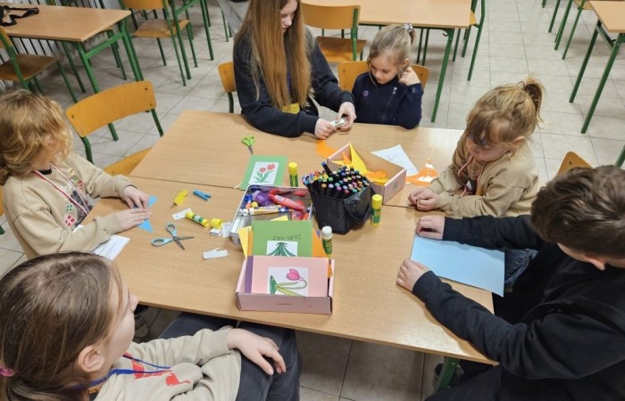 26 lutego w naszej szkole odbył się wyjątkowy DZIEŃ OTWARTY, podczas którego mieliśmy przyjemność gościć przedszkolaków, przyszłych uczniów oraz ich rodziców. Była to doskonała okazja, aby poczuć atmosferę naszej szkoły, poznać jej ofertę edukacyjną i odkryć to, co czyni ją miejscem pełnym pasji, wiedzy i radości.
Zwiedzanie naszej placówki obejmowało sale przedmiotowe, bibliotekę, stołówkę, świetlicę oraz małą salę gimnastyczną, gdzie można było na własnej skórze poczuć rytm codziennego życia naszej szkolnej społeczności.
Na odwiedzających czekało mnóstwo niespodzianek! Zachętą do działania były pieczątki, które najmłodsi otrzymywali w nagrodę za wykonanie przeróżnych zadań. W sali gimnastycznej na uczestników czekały ekscytujące konkurencje sprawnościowe, a w pracowni kulinarnej – pachnące i chrupiące gofry własnej roboty. Młodzi odkrywcy mieli okazję badać świat przez mikroskop, eksperymentować z interaktywnymi robotami Photon oraz brać udział w zajęciach z robotyki. Z kolei miłośnicy sztuki mogli tworzyć piękne dzieła na warsztatach plastycznych i origami, a najmłodsi cieszyli się malowaniem twarzy.
Nie zabrakło także wyzwań dla bystrego umysłu! Gry i zabawy językowe, rebusy oraz polonistyczne łamigłówki rozbudzały wyobraźnię i rozwijały umiejętności językowe. Wesoła „Gimnastyka buzi i języka” sprawiła, że ćwiczenie dykcji stało się czystą przyjemnością. Ogromnym zainteresowaniem cieszyły się również gry planszowe, które dostarczyły mnóstwa radości i emocjonującej rywalizacji. Dodatkowo, zabawy z chustą Klanza okazały się świetnym sposobem na integrację i wspólną zabawę pełną śmiechu.
Aktywne zwiedzanie stało się więc okazją do rozwijania ciekawości świata, nabywania nowych umiejętności, pobudzania w najmłodszych kreatywności oraz odczuwania satysfakcji z osiągniętego sukcesu.