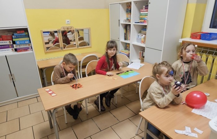 26 lutego w naszej szkole odbył się wyjątkowy DZIEŃ OTWARTY, podczas którego mieliśmy przyjemność gościć przedszkolaków, przyszłych uczniów oraz ich rodziców. Była to doskonała okazja, aby poczuć atmosferę naszej szkoły, poznać jej ofertę edukacyjną i odkryć to, co czyni ją miejscem pełnym pasji, wiedzy i radości.
Zwiedzanie naszej placówki obejmowało sale przedmiotowe, bibliotekę, stołówkę, świetlicę oraz małą salę gimnastyczną, gdzie można było na własnej skórze poczuć rytm codziennego życia naszej szkolnej społeczności.
Na odwiedzających czekało mnóstwo niespodzianek! Zachętą do działania były pieczątki, które najmłodsi otrzymywali w nagrodę za wykonanie przeróżnych zadań. W sali gimnastycznej na uczestników czekały ekscytujące konkurencje sprawnościowe, a w pracowni kulinarnej – pachnące i chrupiące gofry własnej roboty. Młodzi odkrywcy mieli okazję badać świat przez mikroskop, eksperymentować z interaktywnymi robotami Photon oraz brać udział w zajęciach z robotyki. Z kolei miłośnicy sztuki mogli tworzyć piękne dzieła na warsztatach plastycznych i origami, a najmłodsi cieszyli się malowaniem twarzy.
Nie zabrakło także wyzwań dla bystrego umysłu! Gry i zabawy językowe, rebusy oraz polonistyczne łamigłówki rozbudzały wyobraźnię i rozwijały umiejętności językowe. Wesoła „Gimnastyka buzi i języka” sprawiła, że ćwiczenie dykcji stało się czystą przyjemnością. Ogromnym zainteresowaniem cieszyły się również gry planszowe, które dostarczyły mnóstwa radości i emocjonującej rywalizacji. Dodatkowo, zabawy z chustą Klanza okazały się świetnym sposobem na integrację i wspólną zabawę pełną śmiechu.
Aktywne zwiedzanie stało się więc okazją do rozwijania ciekawości świata, nabywania nowych umiejętności, pobudzania w najmłodszych kreatywności oraz odczuwania satysfakcji z osiągniętego sukcesu.