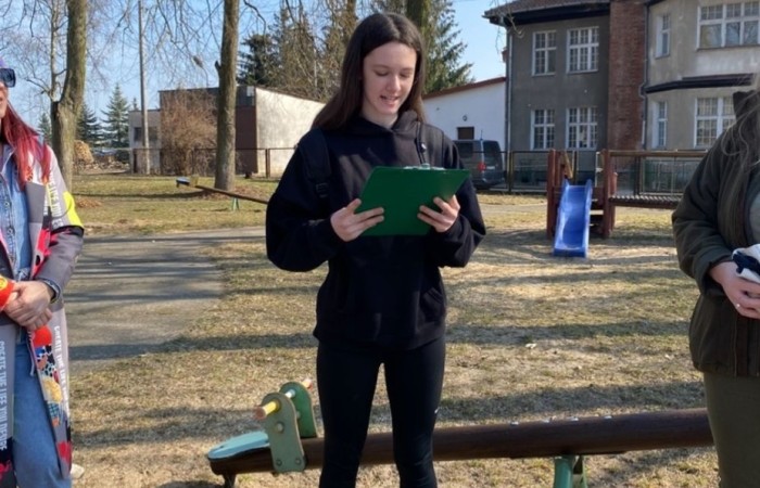 Dzisiaj, w ramach współpracy z Nadleśnictwem Młynary, uczniowie naszej szkoły wzięli udział w akcji sadzenia drzew w pobliskim parku. Wydarzenie miało na celu nie tylko zazielenienie terenu, ale także edukację ekologiczną i budowanie świadomości na temat ochrony środowiska. Pod czujnym okiem leśników dzieci sadziły młode sadzonki buka i lipy. Dodatkowo przed szkołą posadzone zostały sadzonki świerku. Na początku wydarzenia przemowę wygłosiła przewodnicząca samorządu uczniowskiego Lidia Szuniewicz, podkreślając znaczenie troski o naturę.