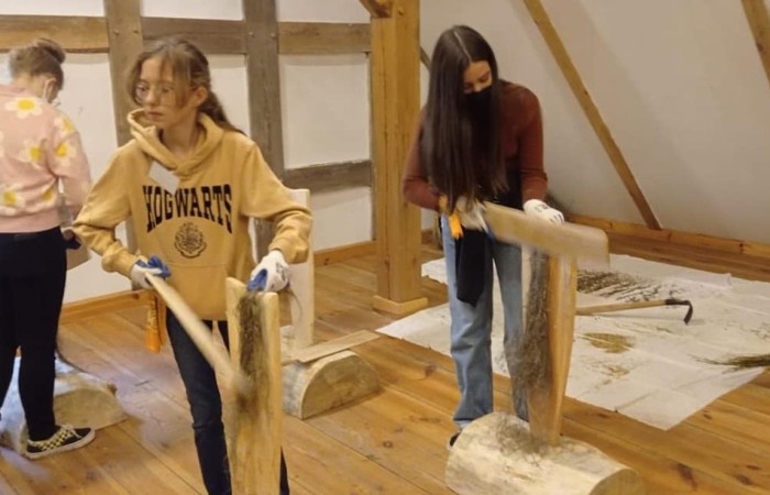 Uczestnicy projektu (19 osób z Francji, 17 z Portugalii i 25 osób z Polski) wyruszyli do Olsztynka. Tam w Muzeum Budownictwa Ludowego poznali piękno architektury naszego regionu i wzięli udział w warsztatach obróbki lnu. Podzieleni na cztery międzynarodowe grupy dowiedzieli się jak wiele lat temu żyli ludzie oraz jak pozyskiwali materiał z lnu. Każdy z uczestników miał okazję 