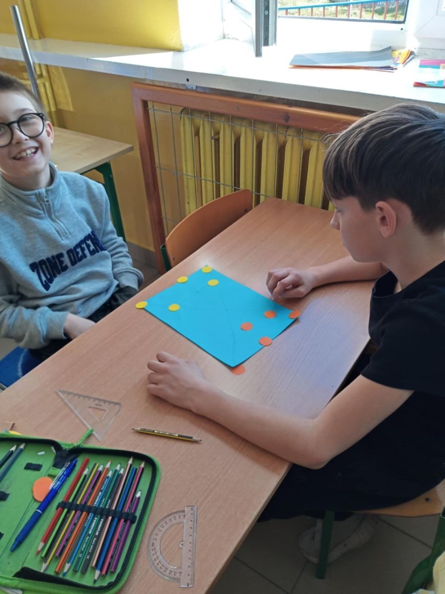 W ostatnim czasie uczniowie klasy 3a mieli okazję połączyć naukę z kreatywnością. W trakcie zajęć matematycznych, dzieci samodzielnie zaprojektowały i przygotowały grę – Trójkątne Warcaby. To doskonały sposób na naukę logicznego myślenia i współpracy. Po wszystkim każdy miał okazję przetestować swoje dzieło i zagrać w nową grę. Podczas zajęć przyrodniczych uczniowie, dzieląc się na zespoły, stworzyli przepiękne plakaty na temat aktualnej pory roku. Po burzliwych dyskusjach o zmianach zachodzących w naturze, każda drużyna zaprezentowała swoją pracę, pełną kolorów i pomysłów.
Jesteśmy dumni z kreatywności i zaangażowania naszych uczniów. 