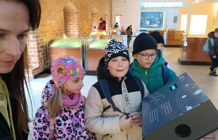 10 kwietnia uczniowie klas pierwszych wyruszyli na wyjątkową wycieczkę do Fromborka, miasta związanego z postacią Mikołaja Kopernika – wybitnego astronoma, który „wstrzymał Słońce, ruszył Ziemię”. Największą atrakcją było oczywiście Planetarium, gdzie dzieci mogły przenieść się w sam środek kosmosu – zobaczyć planety, gwiazdy i dowiedzieć się, jak wygląda Wszechświat oczami współczesnych odkrywców. Nie zabrakło też spaceru po wzgórzu katedralnym i odrobiny historii – uczniowie odwiedzili miejsca, w których żył i pracował sam Kopernik.
Z nową wiedzą, mnóstwem wrażeń i szerokimi uśmiechami wróciliśmy do szkoły. To była naprawdę udana podróż – zarówno w czasie, jak i przestrzeni. Zapraszamy do obejrzenia zdjęć z naszej wyprawy.